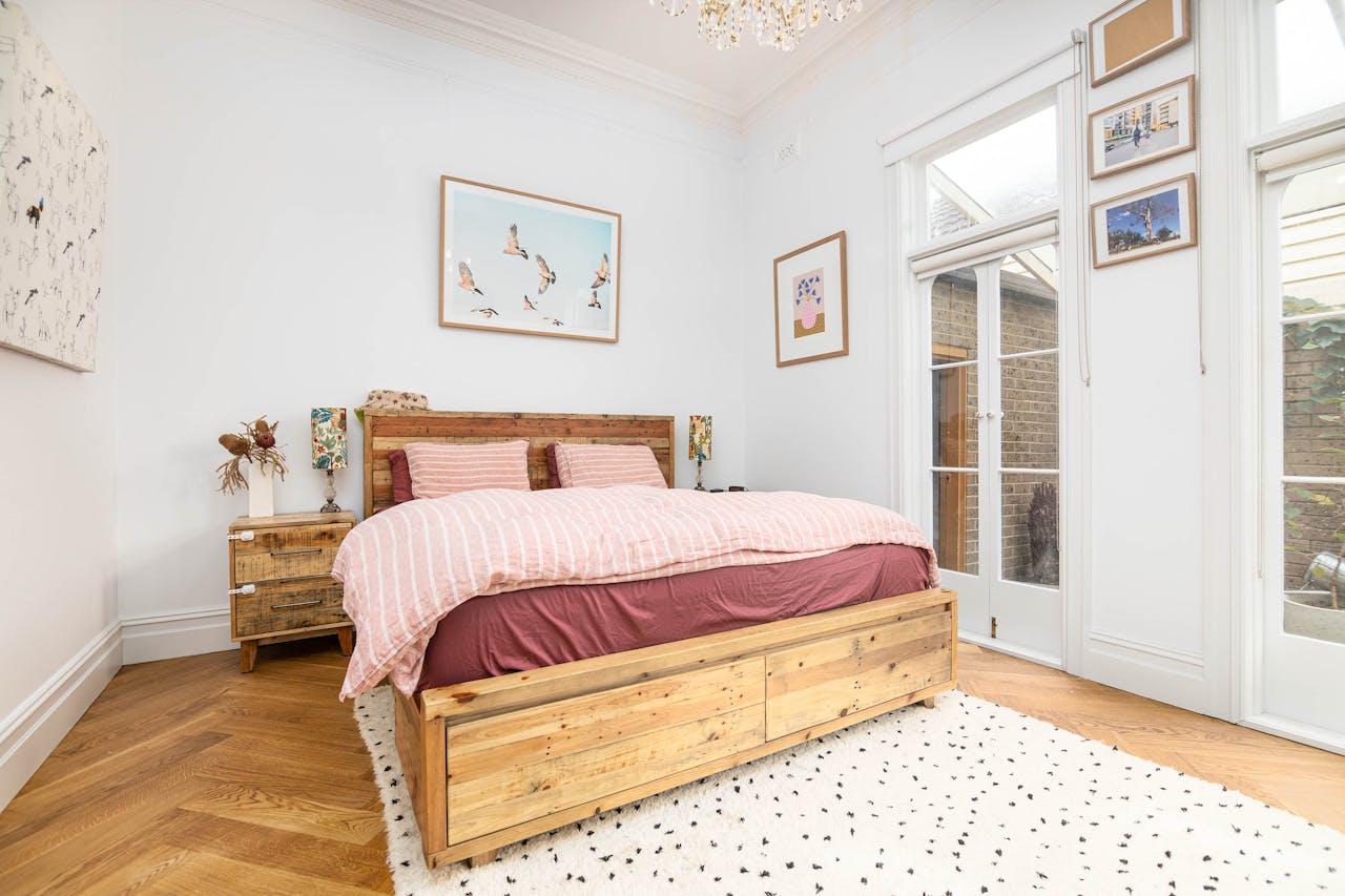 Mastering the First Impression: Your intriguing post title goes here Bright and airy bedroom with rustic wood furniture, cozy decor, and natural light.
