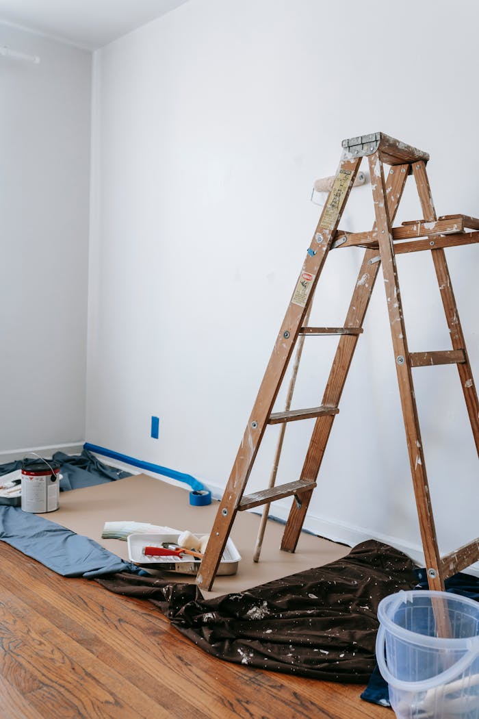 Crafting Captivating Headlines: Your awesome post title goes here A home renovation scene featuring a wooden ladder, painting tools, and white walls in a room.